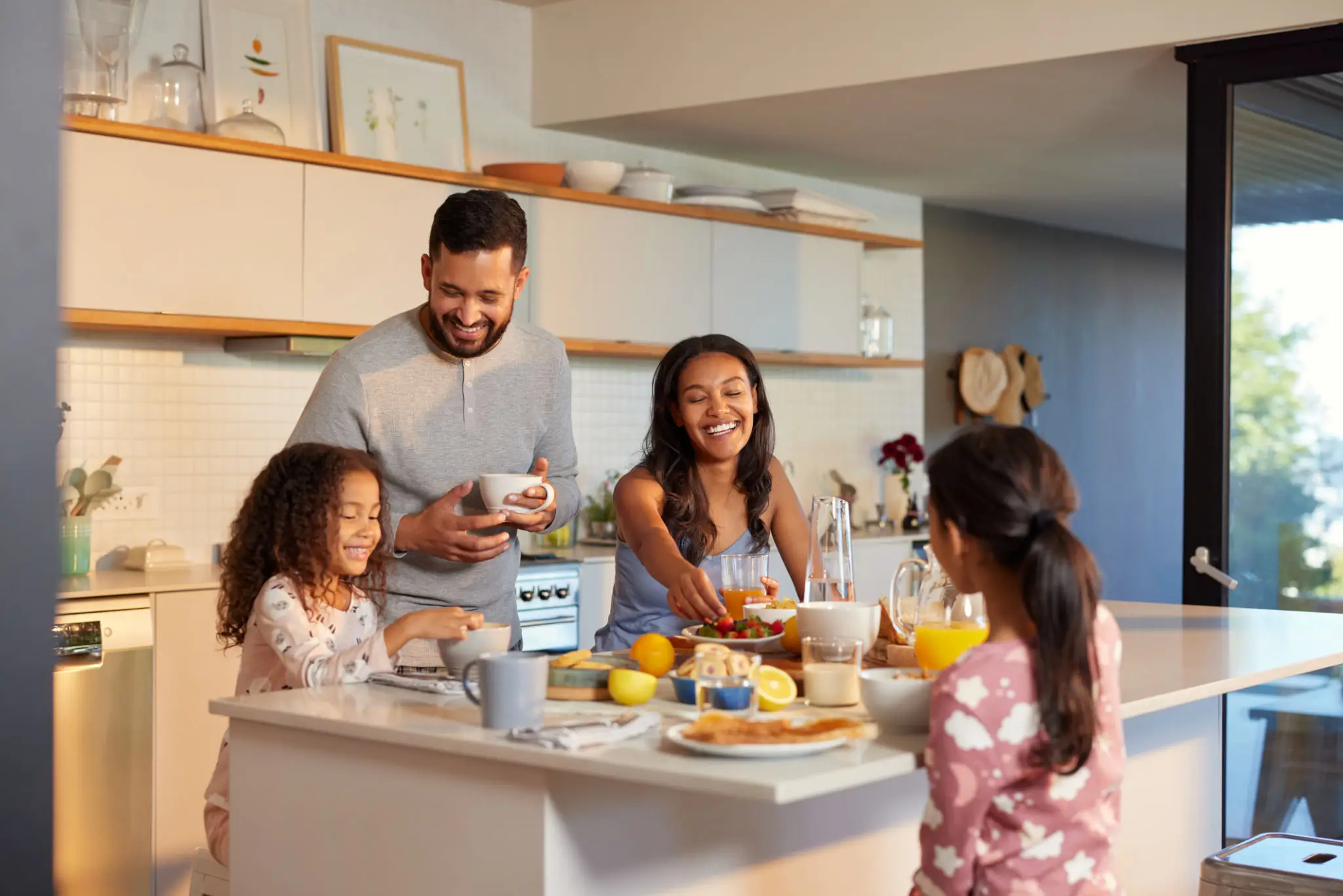 Family enjoying breakfast together in a modern kitchen.