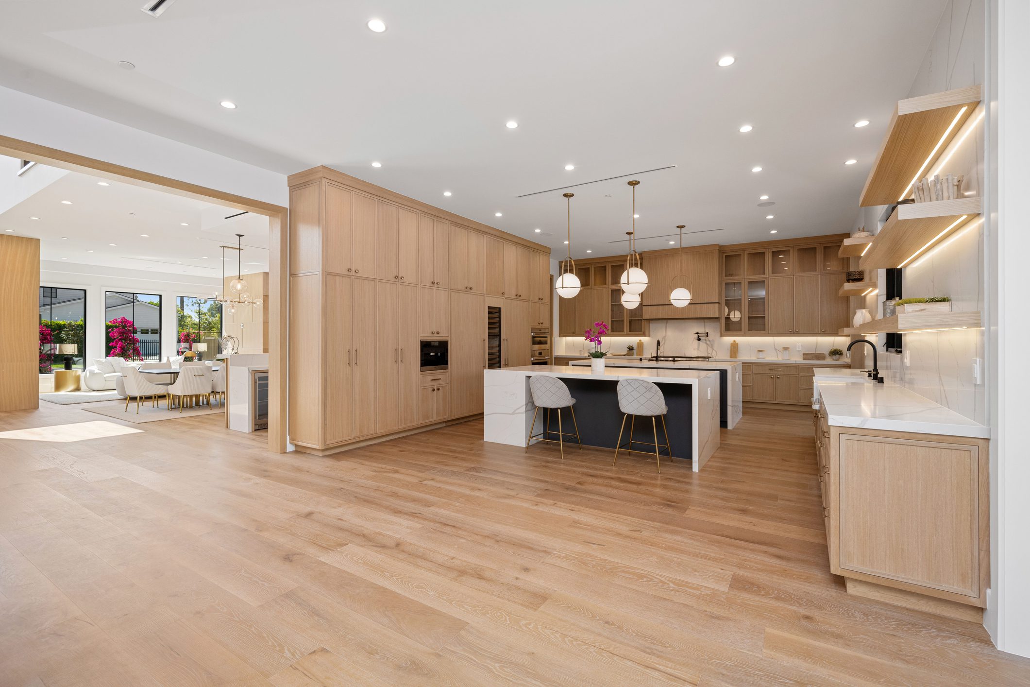 Spacious modern kitchen with wooden floors and minimalist design.
