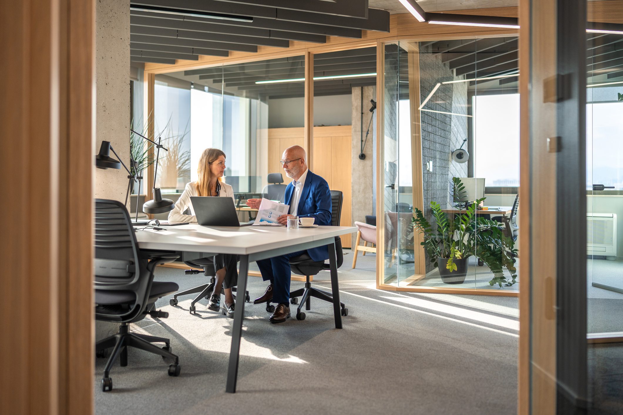 Two professionals discussing work in a modern office.